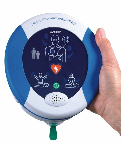 A hand holding a HeartSine Samaritan 350P AED, displaying visual instructions on its screen and emphasizing the Pad-Pak cartridge for seamless portable defibrillation technology.