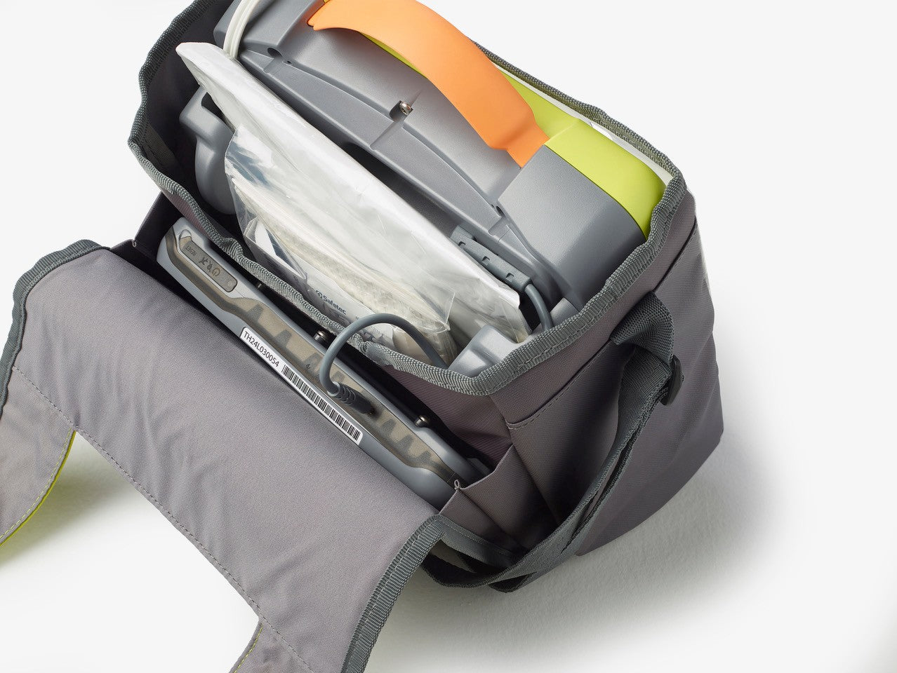 Gray bag with a compartment containing electronic devices on a white background
