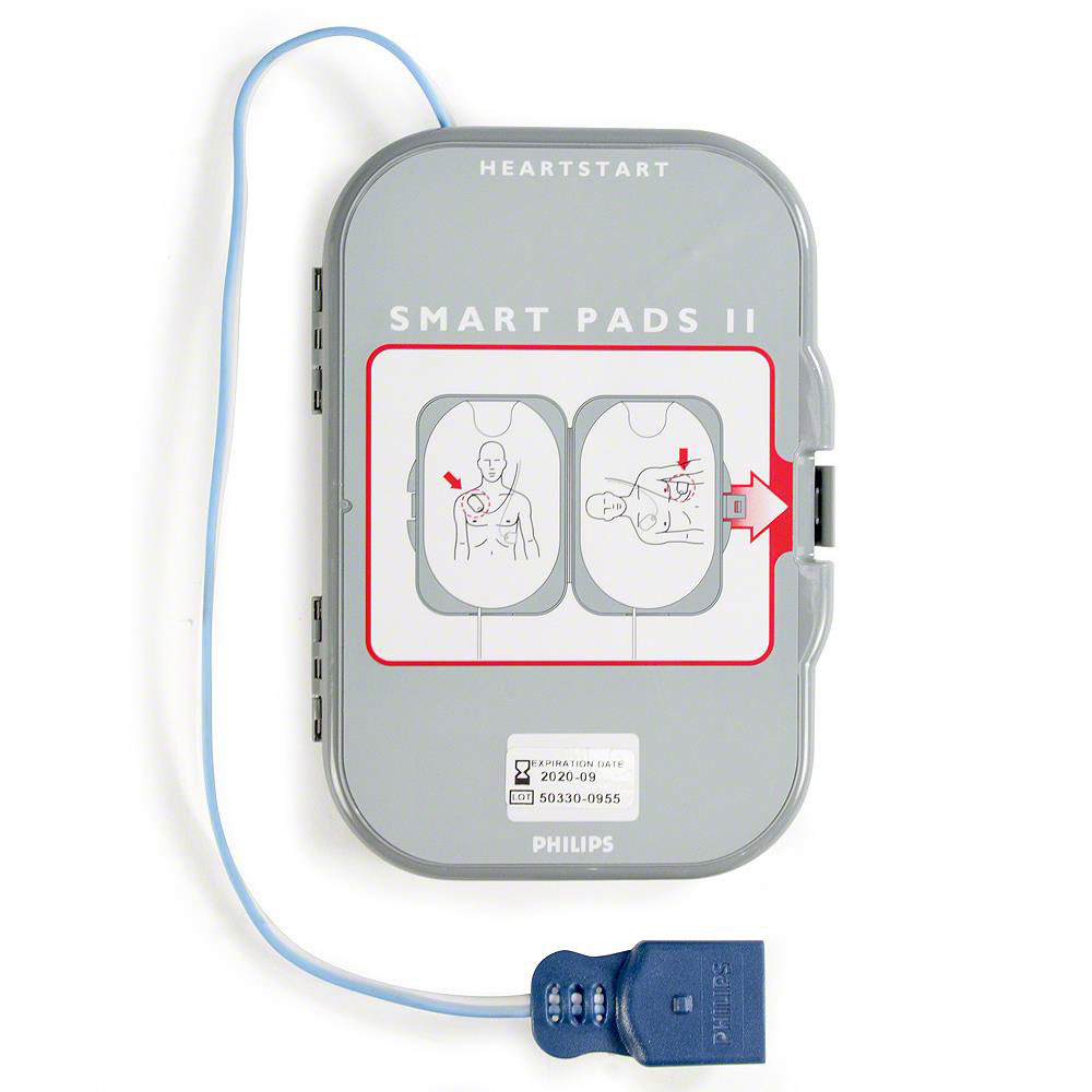 Close-up of the Philips FRx SMART Pads II Defibrillation Electrode Pads. The gray case features illustrations showing pad placement on a human torso for defibrillation. A connected cable extends from the case and ends in a blue connector. The words "HeartStart" and "SMART Pads II" are visible.