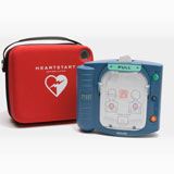 Portable automated external defibrillator (AED) with instructions and a red carrying case labeled "HEARTSTART." Includes a handy Philips OnSite Adult SMART Pads Cartridge installation guide.