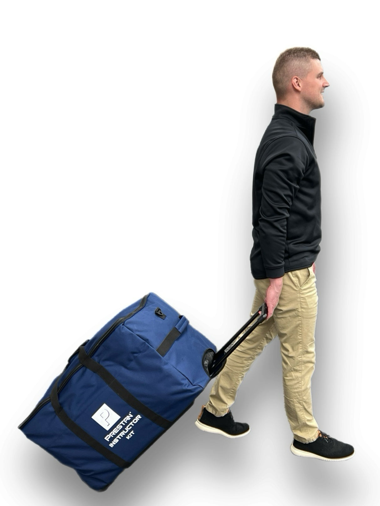 A man in a black jacket and beige pants pulls a large blue rolling bag labeled "Property Instructor Set," which includes the PRESTAN Instructor Kit by Prestan.