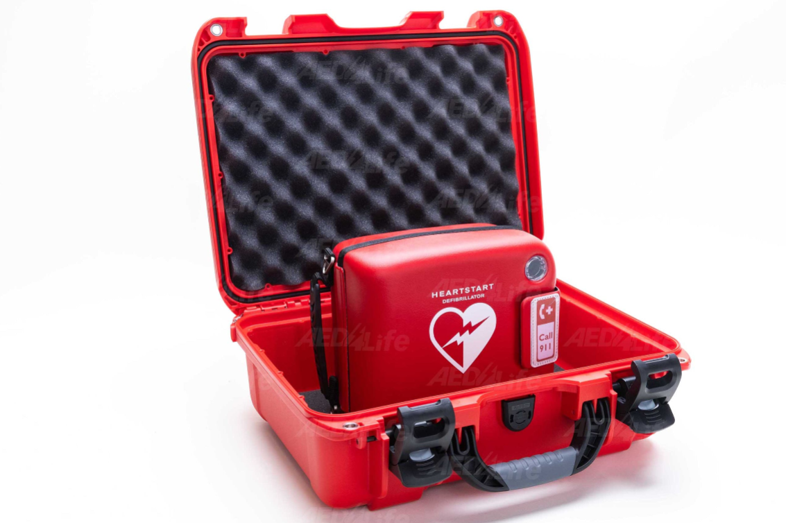 Red HeartStart defibrillator in an open protective case on a white background