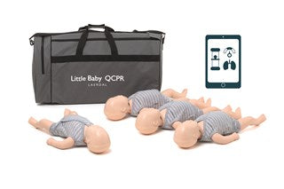 Four infant CPR manikins laying on the ground beside a large grey with black handles.