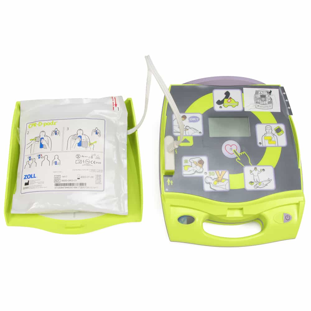 The ZOLL AED Plus by ZOLL, featuring instruction graphics and attached electrode pads in a bright green tray, offers Real CPR Help to guide you during emergencies.